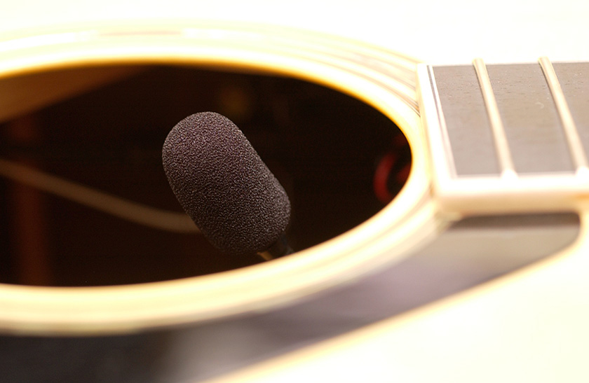A condenser microphone placed inside a guitar