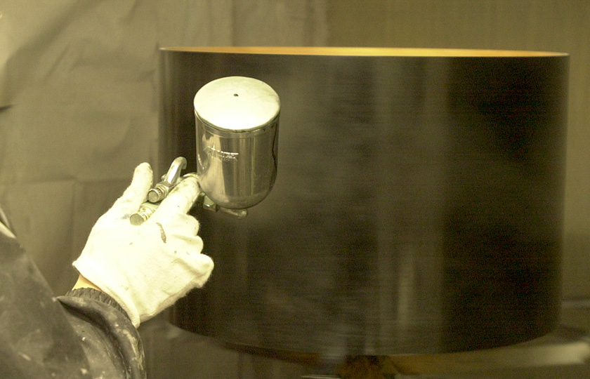 Paint is applied with a sprayer to give a flat black finish.