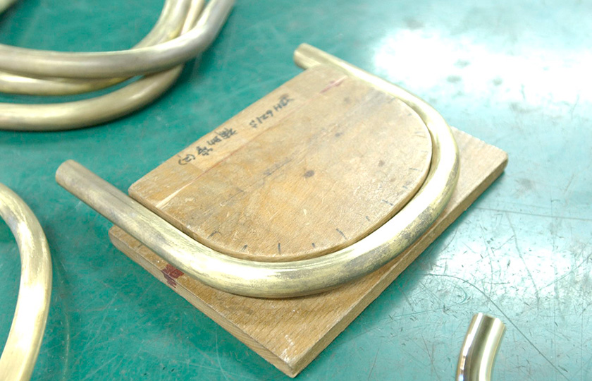 A wooden mold used to check for the proper bend