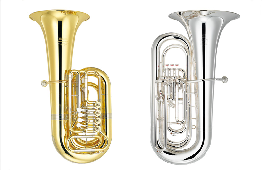 On the left is a brass tuba with a clear lacquer finish; on the right is a brass tuba with silver plating.