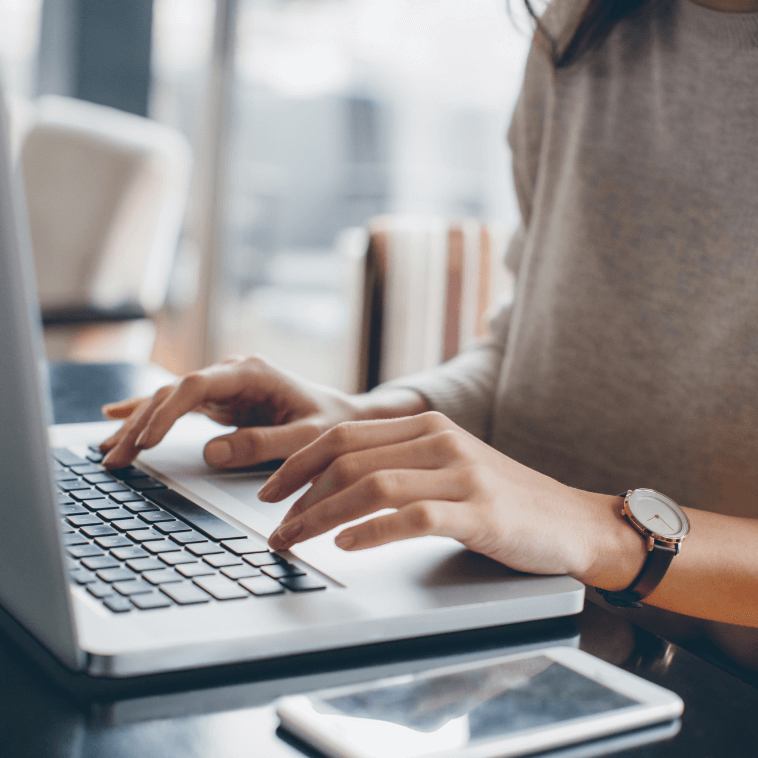 hands typing in a laptop keyboard