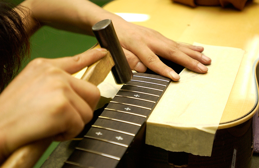 Frets are hammered into the fingerboard