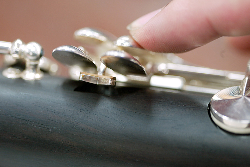 Mechanism for the little finger which enables the upper key to move as well when the lower key is pressed.