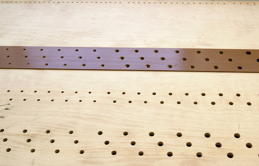 On the top of the wind-chest, the holes and slider for the three timbres.