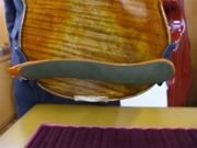 A shoulder rest attached to a violin. Attach the rest at the angle that makes it easiest to play