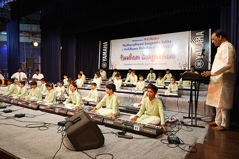 Teacher leading the 30 keyboard students ensemble