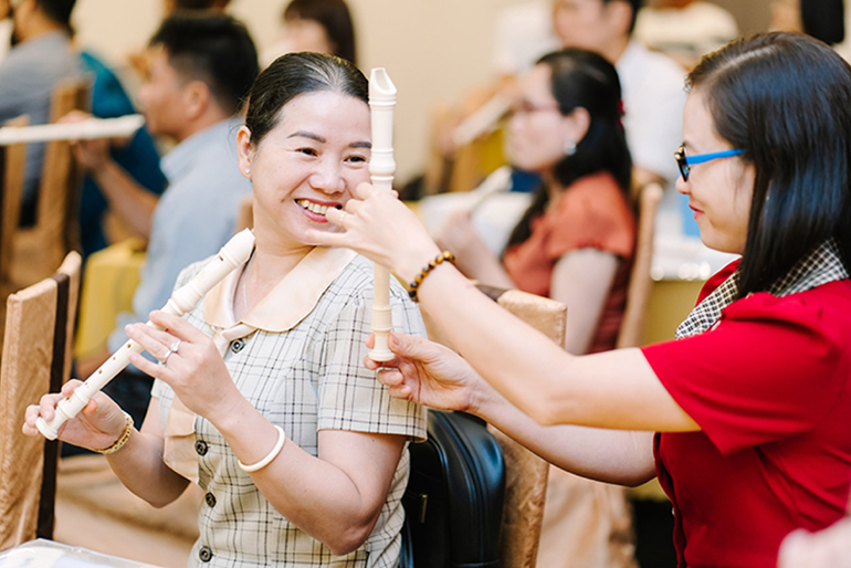 [Image] Vietnamese teachers checking recorder fingerings during training
