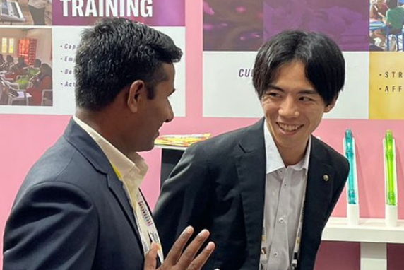 [Image] A Yamaha employee talking with external stakeholders at an education-related event in India