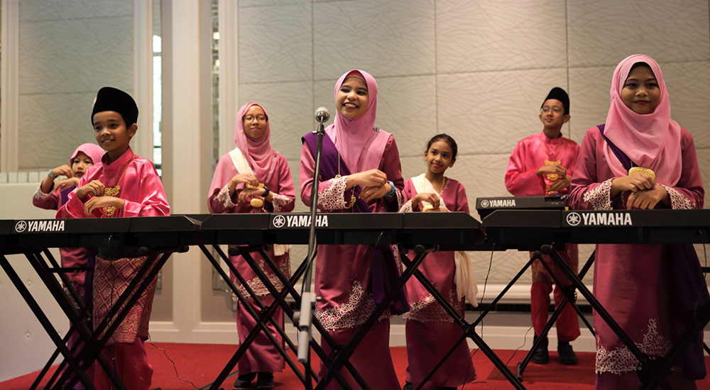 Malaysian children enjoying self-expression and performance with a keyboard