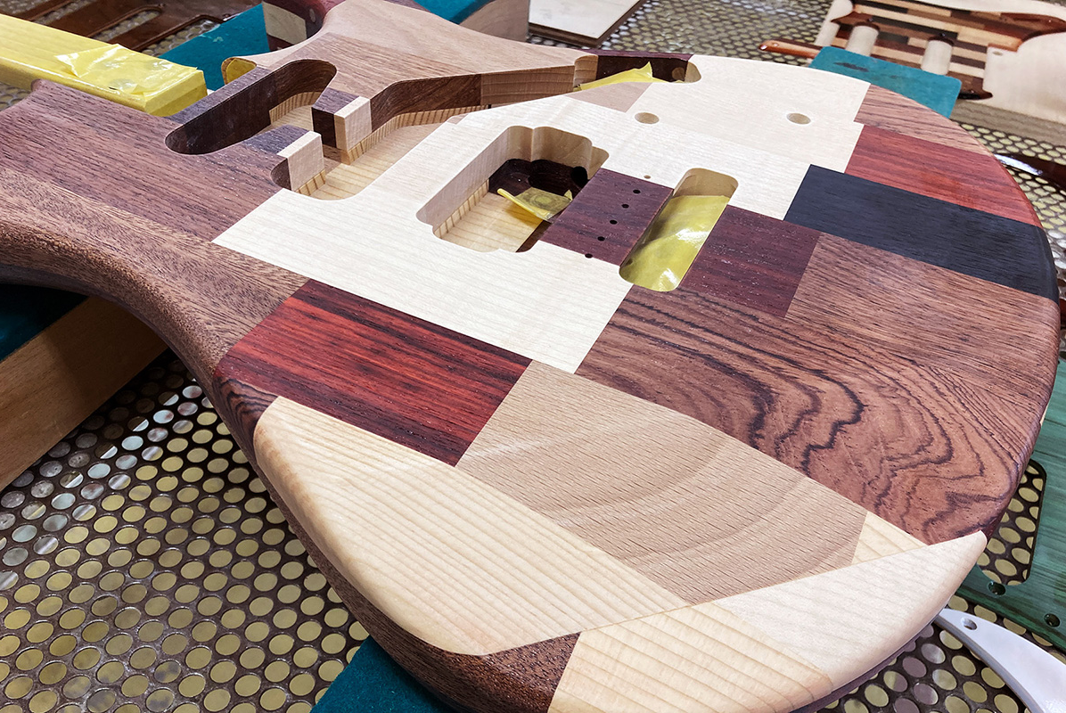 The first prototype of an upcycling guitar featuring a patchwork of unused wood pieces originally meant for various instruments.