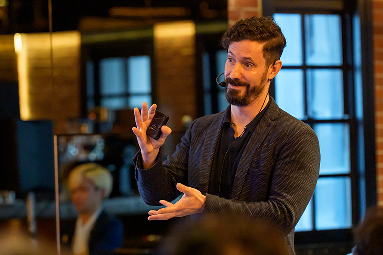 [Photo] A Moodsonic representative delivering a presentation on stage with expressive gestures during the TRANSPOSE Innovation Challenge final pitch.