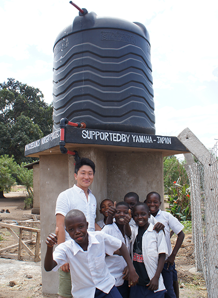 ［ 写真 ］村内に設置した貯水タンクと子どもたち
