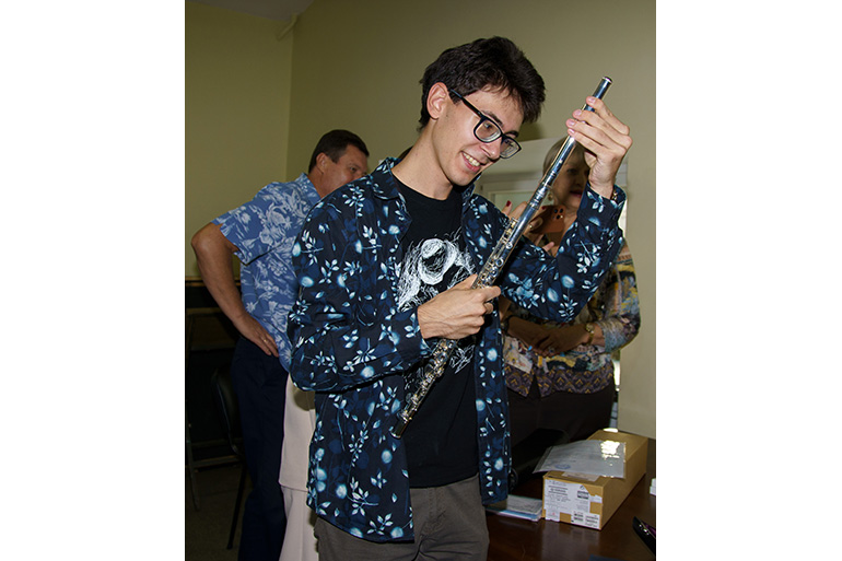 [写真] 届いたハンドメイドフルートを手に取る団員