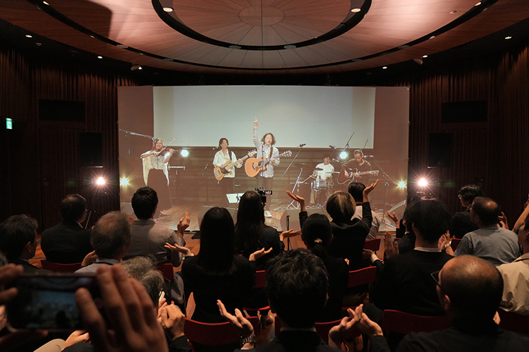 [写真] 低遅延で転送された音声・映像・照明でライブを楽しむサテライト会場の様子