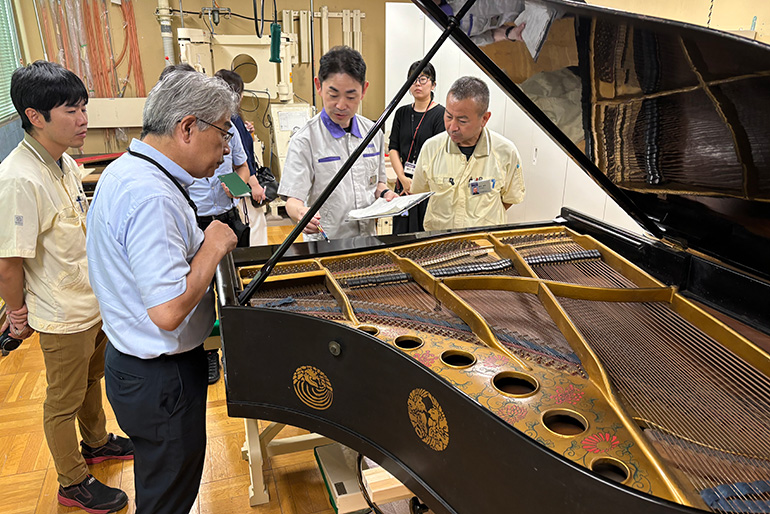 [写真] ヤマハ掛川工場にて。東京藝術大学の松本達弥先生（左から2人目）とともに修理作業の確認を行うヤマハスタッフ