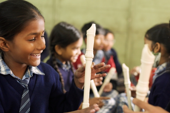 [画像] 音楽の授業の時間にペアワークで運指を確認するインドの児童たち