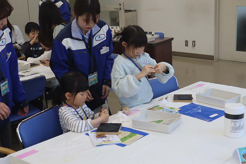 [写真] カスタネット制作を行う参加者の子供たちとサポートするスタッフ