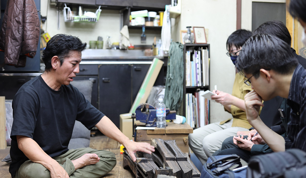 [写真] 三線職人の話を聞くヤマハ社員