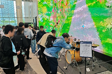 [写真] 自動演奏に用いられた楽器を見学する来場者