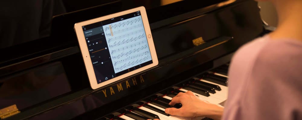 person playing the piano with ipad