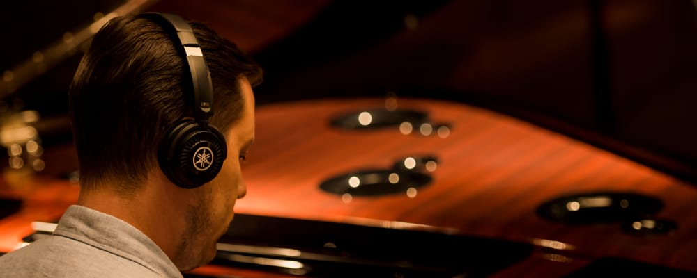guy with a headset and piano in a blur background