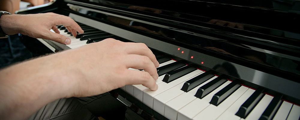 close-up photo of two hands playing csp piano keys