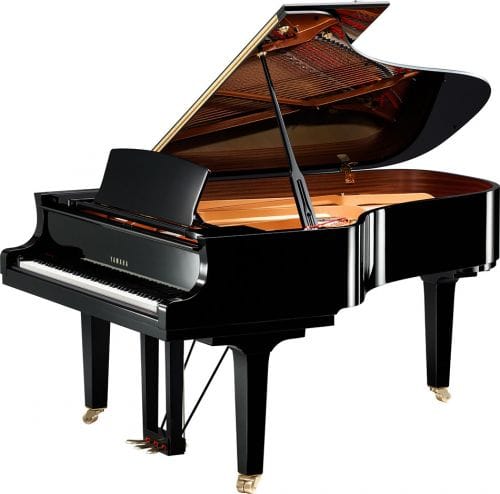Image of small Yamaha baby grand piano with lid open viewed from right side.