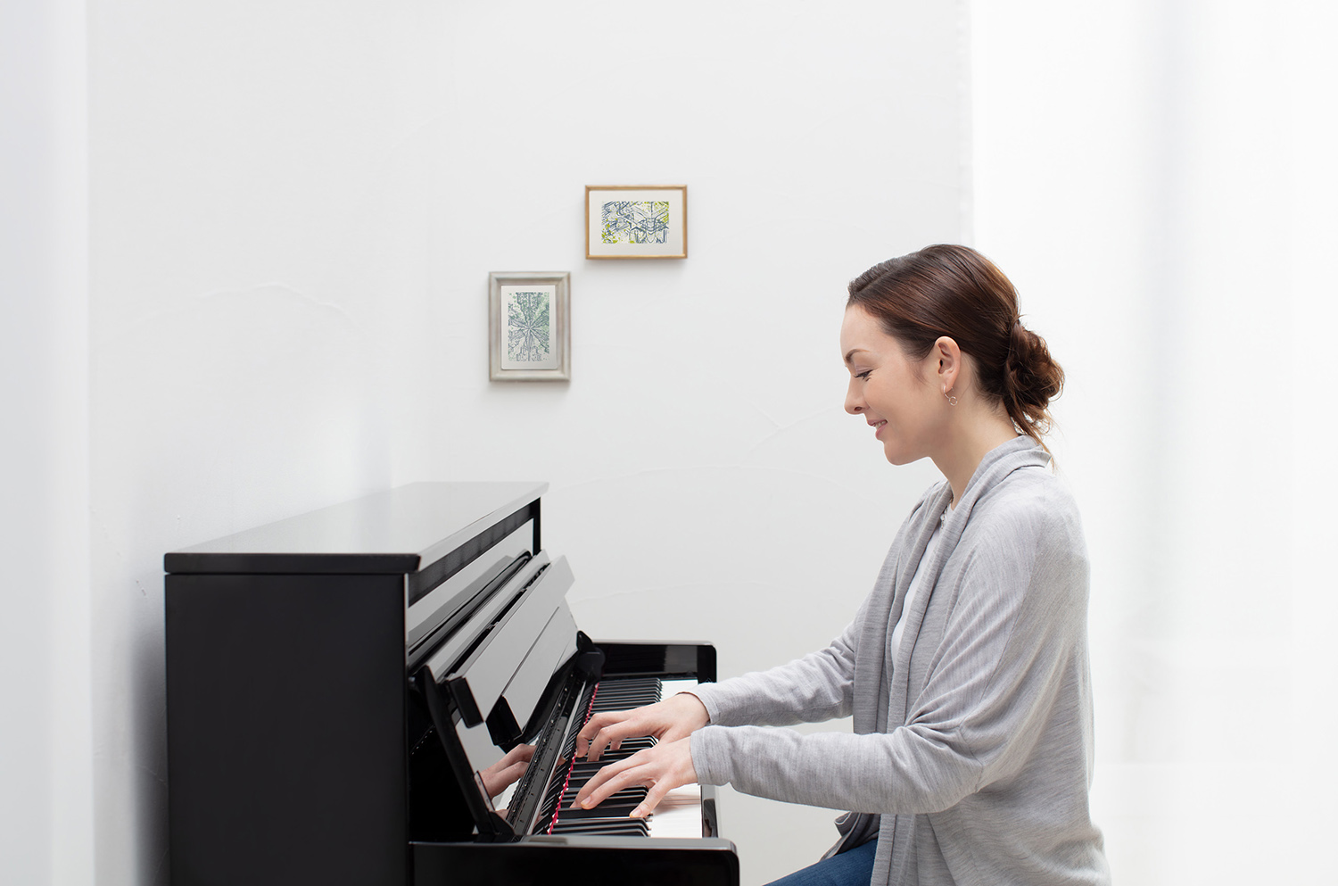 An older man in a suit playing a grand piano.