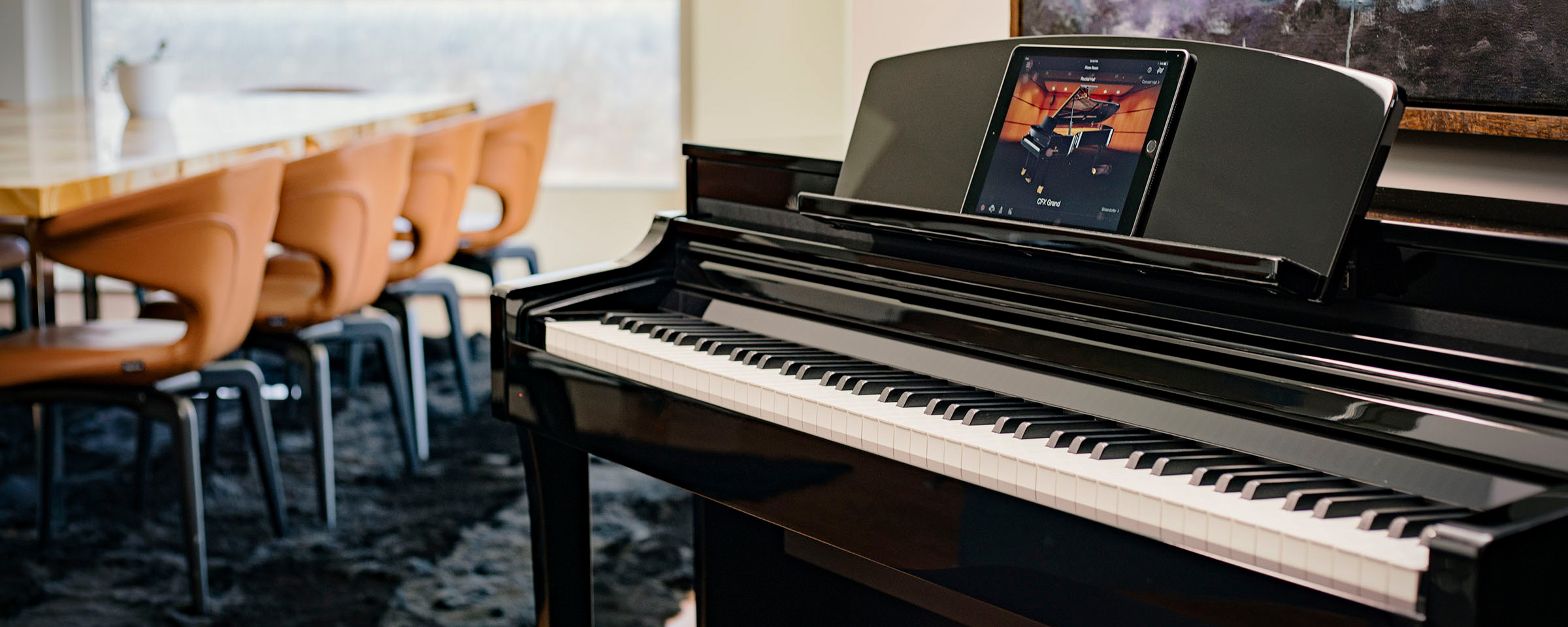 Man in his 20's dressed casually with curly hair and some facial hair playing a Yamaha piano.