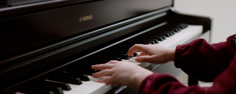 hands playing the keys of a piano