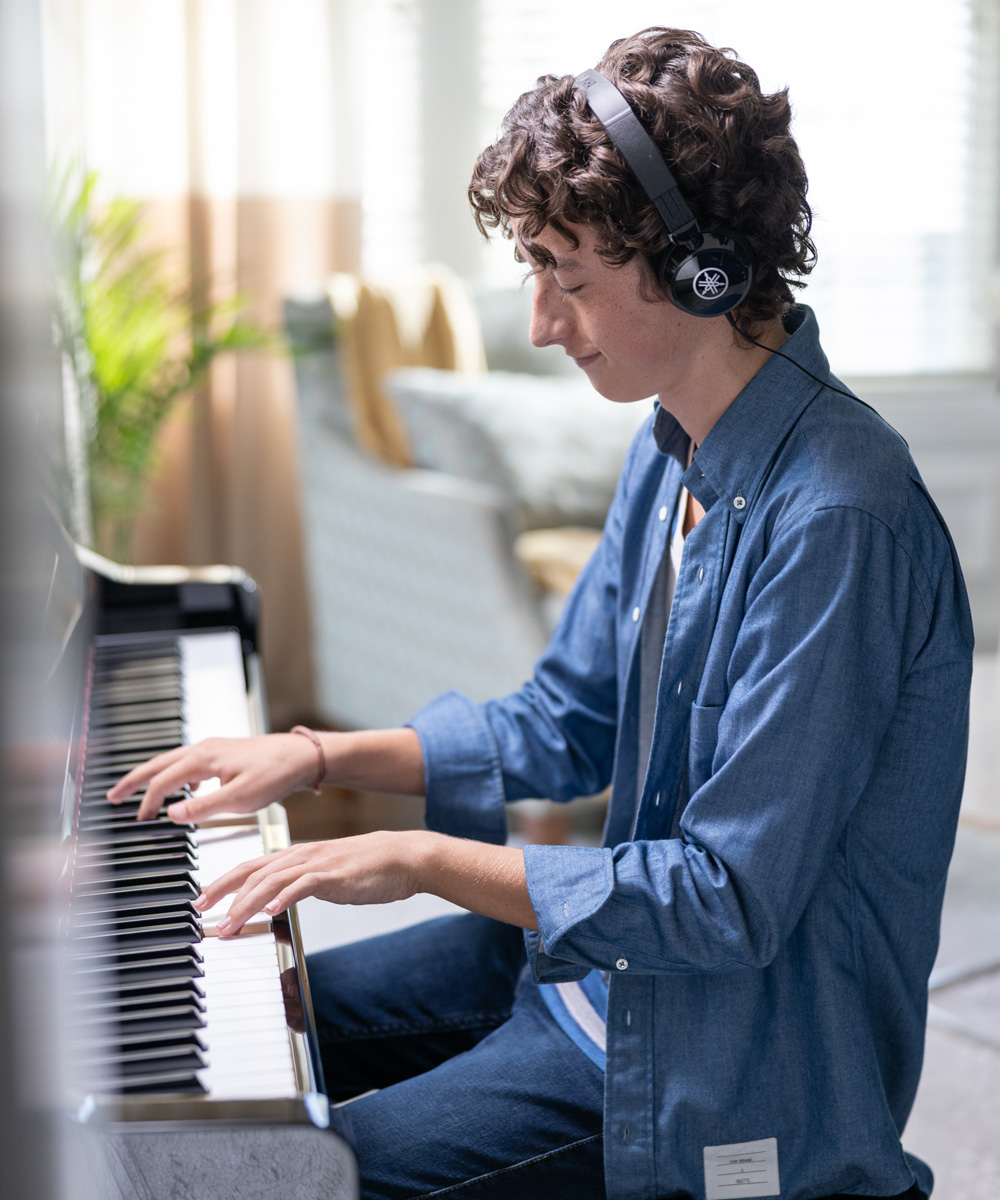 teenager wearing a headset playing a hybrid piano