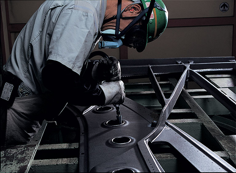 Yamaha machinist working on a metal piano frame