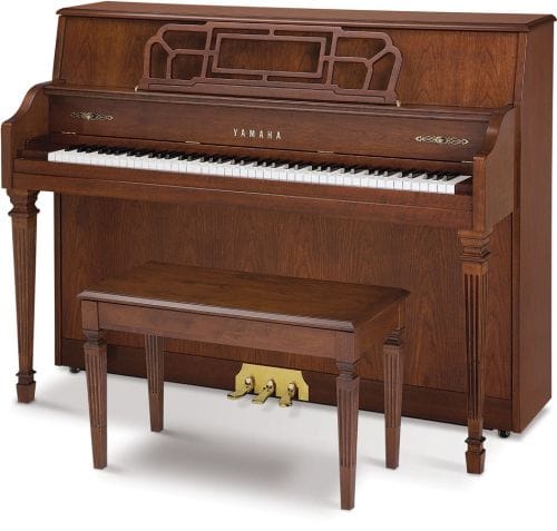 Yamaha upright piano and bench in a more traditional furniture style with squared legs with grooves.