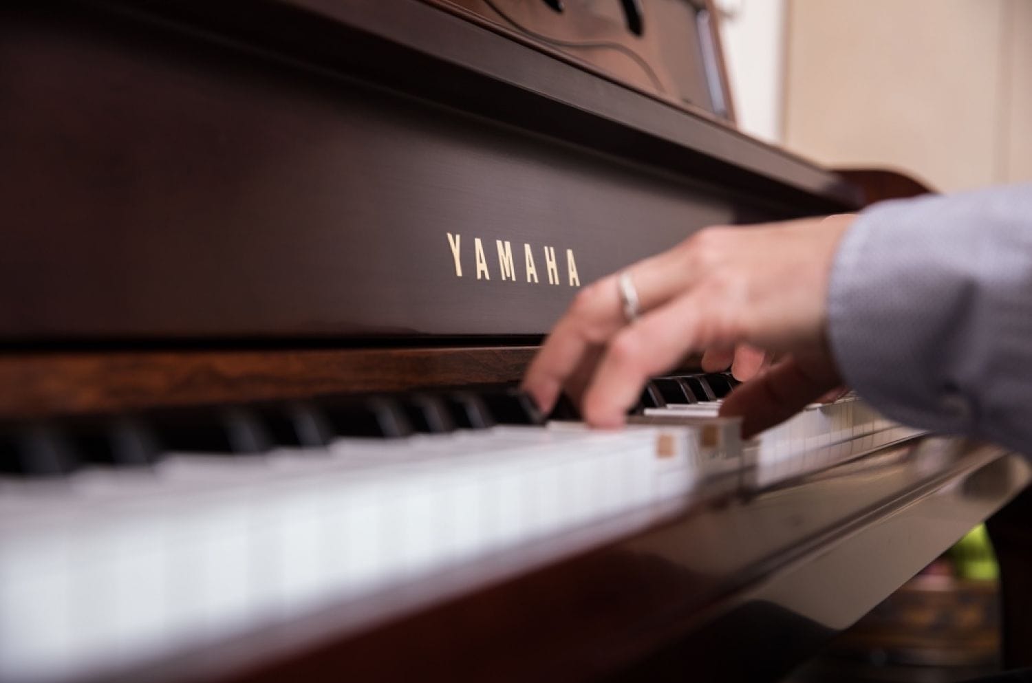 Closeup from side angle of man's hands playing piano.