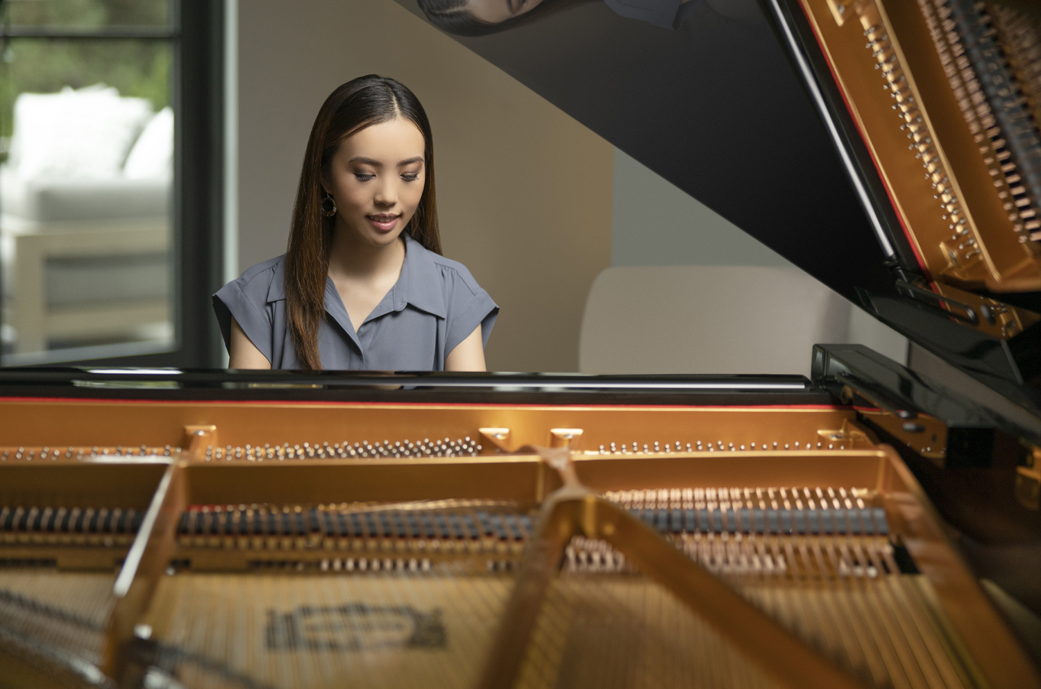 An older man in a suit playing a grand piano.