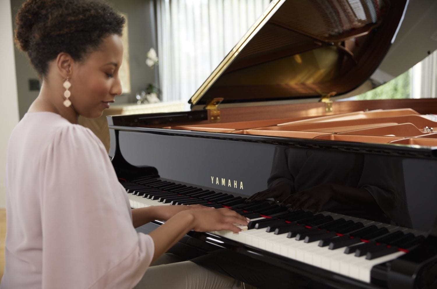 a woman playing a CX-Series piano