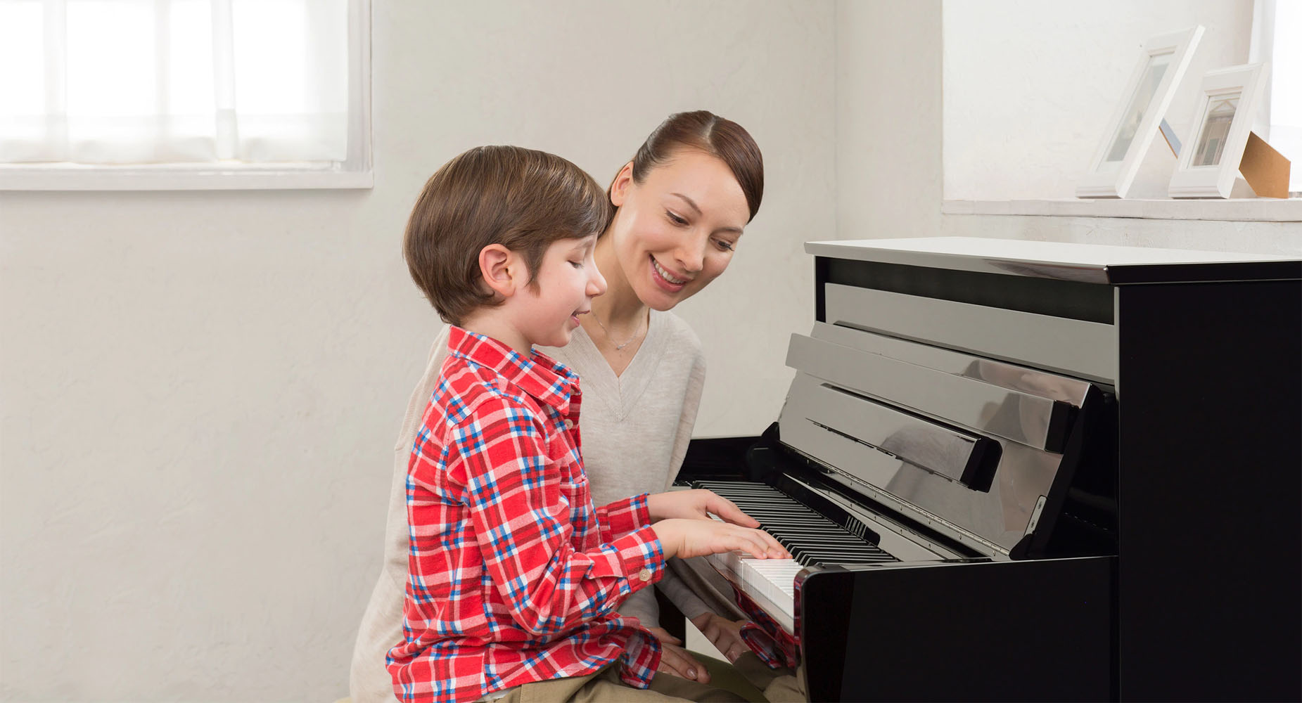 happy mother and son playing clavinova piano