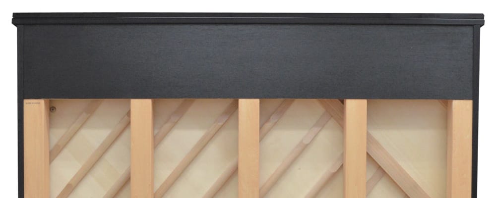 Le dos d'un piano droit avec vue sur les poteaux supportant la planche.