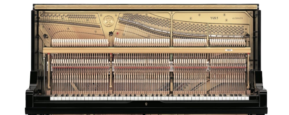 An upright piano with lid open displaying interior.