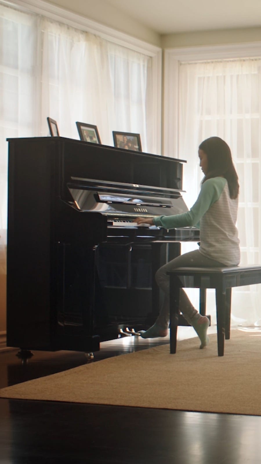 girl sitting playing the upright piano